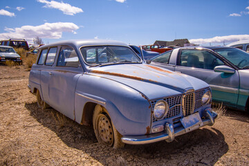 Fototapeta na wymiar Exterior of a junked vintage retro vehicle in a junkyard.