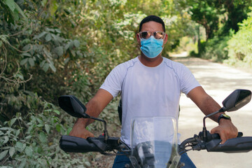 Young motorcyclist with protective mask driving a motorcycle