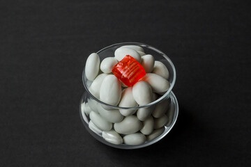 Traditional Turkish Hard Almond Candies designed in glass bowl on black surface with copy space.Conceptual image of celebrations