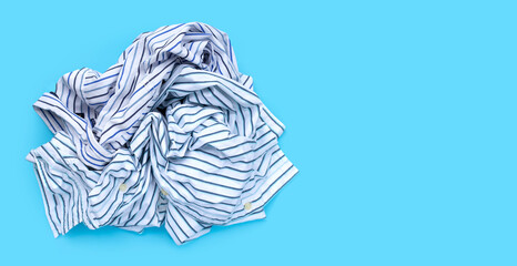 Pile of used clothes on blue background.