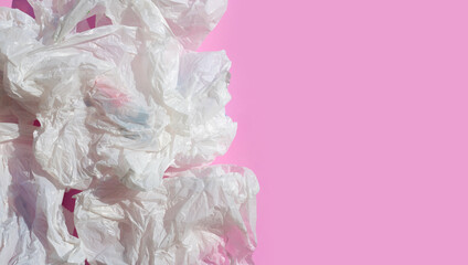 Fototapeta premium White crumpled plastic bags on pink background.