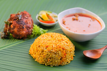 Nasi Beriyani , Gulai Kawah and Ayam Berempah served on green leaf.