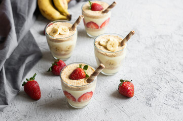 Magnolia dessert with fresh bananas and strawberries in glass cup, homemade milky dessert concept