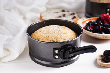 fresh baked fruit cake in metal spring form with fruits and berries on plate. White background, healthy food consept