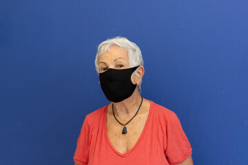Mulher idosa usando máscara por causa de pandemia COVIDE