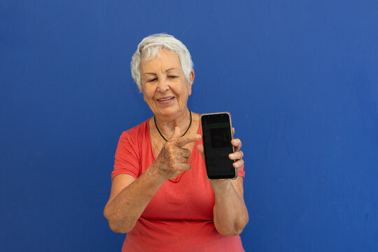 Mulher idosa curiosa com telefone celular 