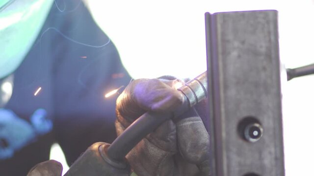 Close up footage of welding metal, showing protective gloves and sparks in high level of detail