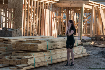 Shocked home builder examining a pile of expensive lumber being used to construct a new home