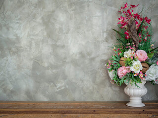 Beautiful colorful bouquet flowers in the white vintage vase decoration on wooden table on loft-style concrete wall background with copy space.