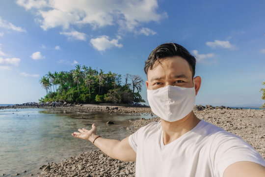 Asian man with face mask has a summer sea trip while in Covid-19 pandemic. - Powered by Adobe