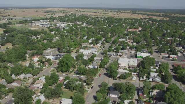 Aerial View over Red Bluff California of Houses and Streets with Cars with Green Trees and Dry Grass