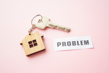 Wooden house toy and silver key on bright pink background with phrase quote Problem. Mortgage, house buy sell, investment, rent, realtor concept