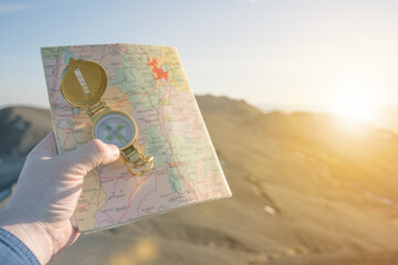 compass map in the hand of a traveler on a background of nature. active recreation on top of the...