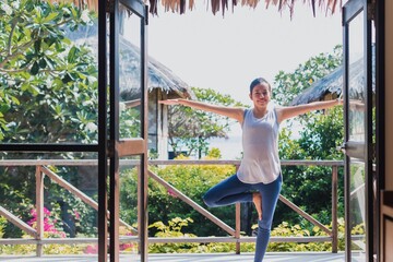 Obraz premium Asian beautiful woman exercise and play yoga at home.Concept of Exercise during the quarantine at home for preventing coronavirus and covid-19 infection.