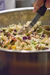 serving spoon stirring a green healthy salad