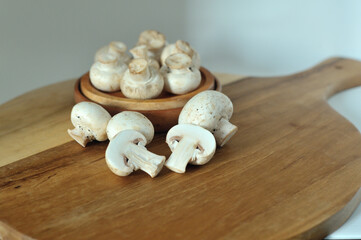 Mushrooms on a wooden chopping board on a white background
