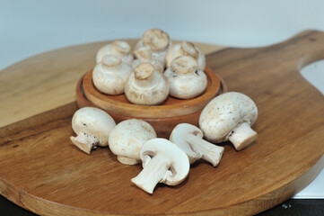 Mushrooms on a wooden chopping board on a white background