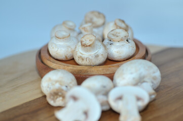 Mushrooms on a wooden chopping board on a white background