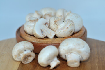 Mushrooms on a wooden chopping board on a white background