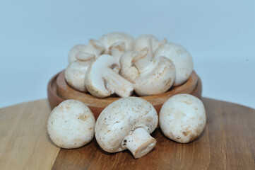 Mushrooms on a wooden chopping board on a white background
