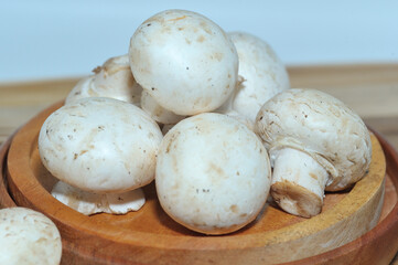 Mushrooms on a wooden chopping board on a white background