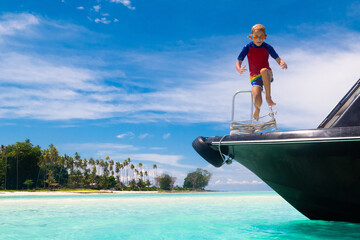 Fototapeta premium Child jumping into sea water. Yacht vacation.