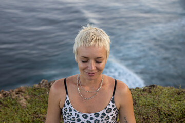 Portrait of woman with closed eyes. Short blond hair. Practicing meditation and pranayama breathing...