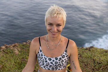 Portrait of woman with short blond hair. Practicing meditation and pranayama breathing exercise....