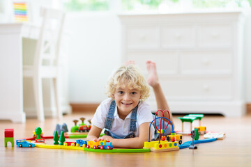 Kids play wooden railway. Child with toy train.