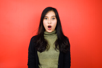 Young beautiful asian women using black sweater with red isolated background