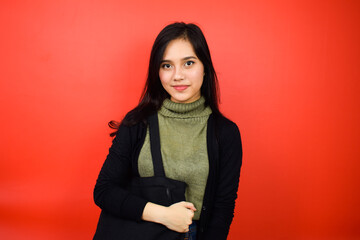 Fototapeta premium Smiling and look at camera of Young beautiful asian women using black sweater with red isolated background