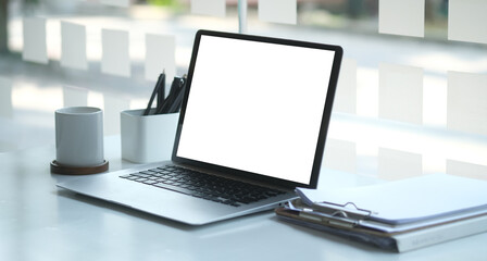 Fototapeta premium Modern workspace with computer with blank screen and equipment on white table.Blank screen for your information.