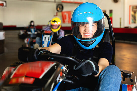 Glad cheerful woman driving sport car for karting in a circuit lap in sport club