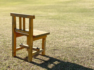 芝生に置いた木製の椅子1つ