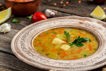 Homemade vegan lentil soup with vegetables on wooden background. Indian vegetarian cuisine. Food recipe background. Close up