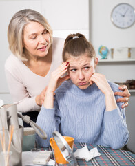 Senior woman trying to comfort her sad adult daughter at home