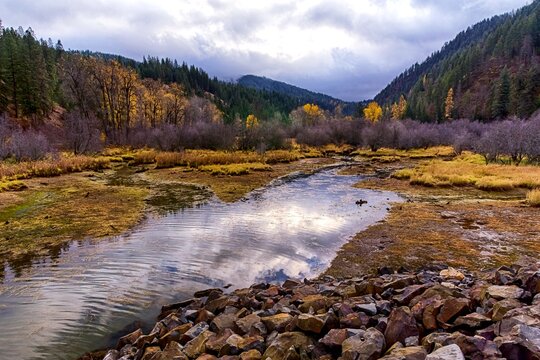 Autumn landscape. Water stream, hills and sky reflection. Lonesome Creek in autumn season. Coeur D`Arlene Lake area, Idaho