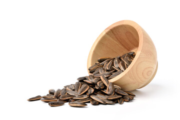 Sunflower seeds pouring from wooden bowl isolated on white background.