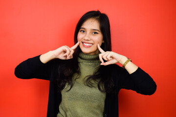Young beautiful asian women using black sweater with red isolated background