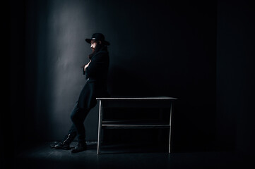 A man in a hat with a beard looks out the window