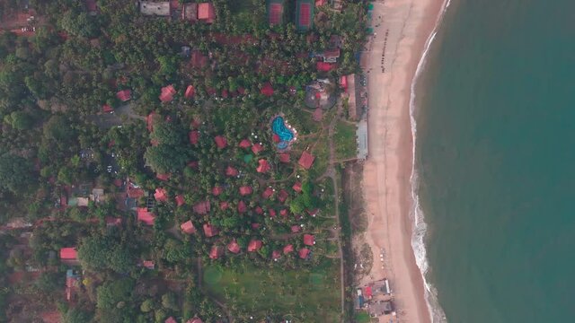goa Sinquerim Beach drone shot shack view from the beach to waves top birds-eye view  extreme top cinematic villa hotel by the beach