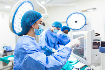 Anesthesiologist keeping track of vital functions of the body during cardiac surgery. Surgeon...