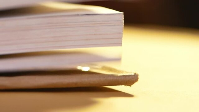 Flipping book pages close up. Looking through the corner of the book on table.