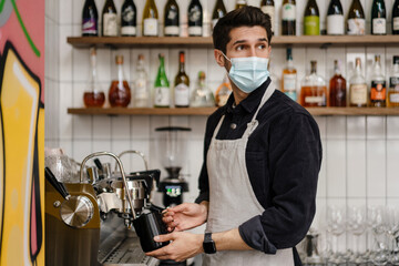 Young white brunette man in apron and protective mask