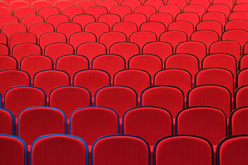 Rows of empty red chairs in concert hall