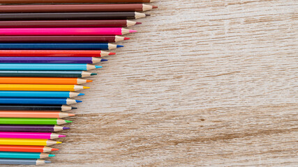 Obraz premium Colorful colored pencils arranged on a wooden table