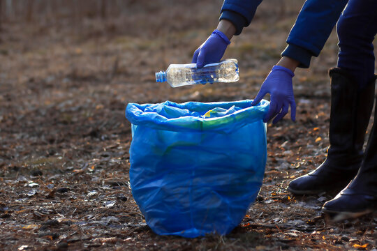 Girl collects plastic . Puts it in a garbage bag. The problem of environmental pollution from plastic waste.. Ecological pollution. Problem of ecology.