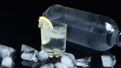 bottle of vodka and glass with lemon