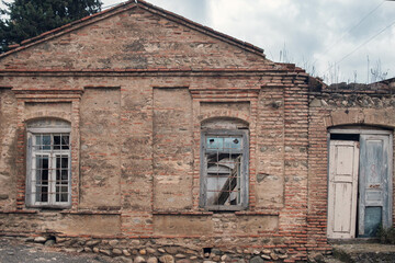 Fototapeta na wymiar facade of an old abandoned house made of stone bricks