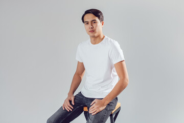 Attractive asian man in white t-shirt on white background.